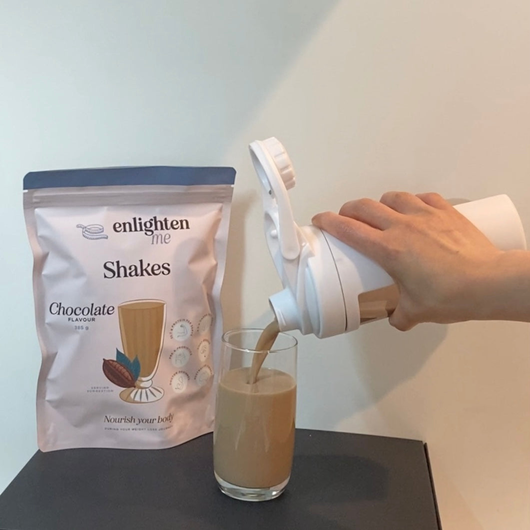 A picture demonstrating the Enlighten Me Shake in Chocolate flavour, a high protein meal replacement shake for weight loss, being poured from an Enlighten Me Shaker into a glass to serve.